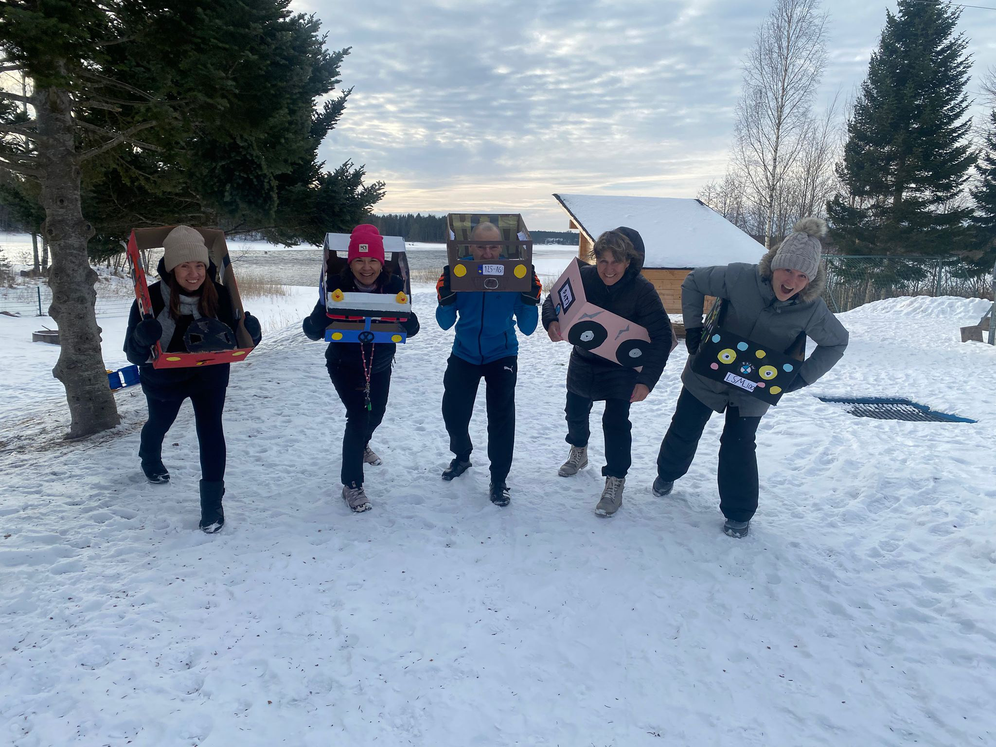 Viisi henkilöä seisoo rivissä ulkona talvipäivänä.